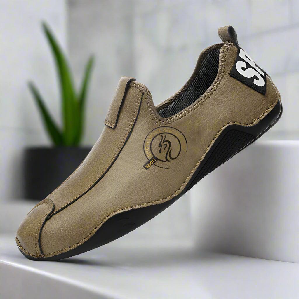 Brown slip-on shoe with black sole on a white background