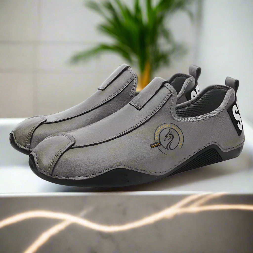 Pair of gray slip-on shoes with a logo on a white background