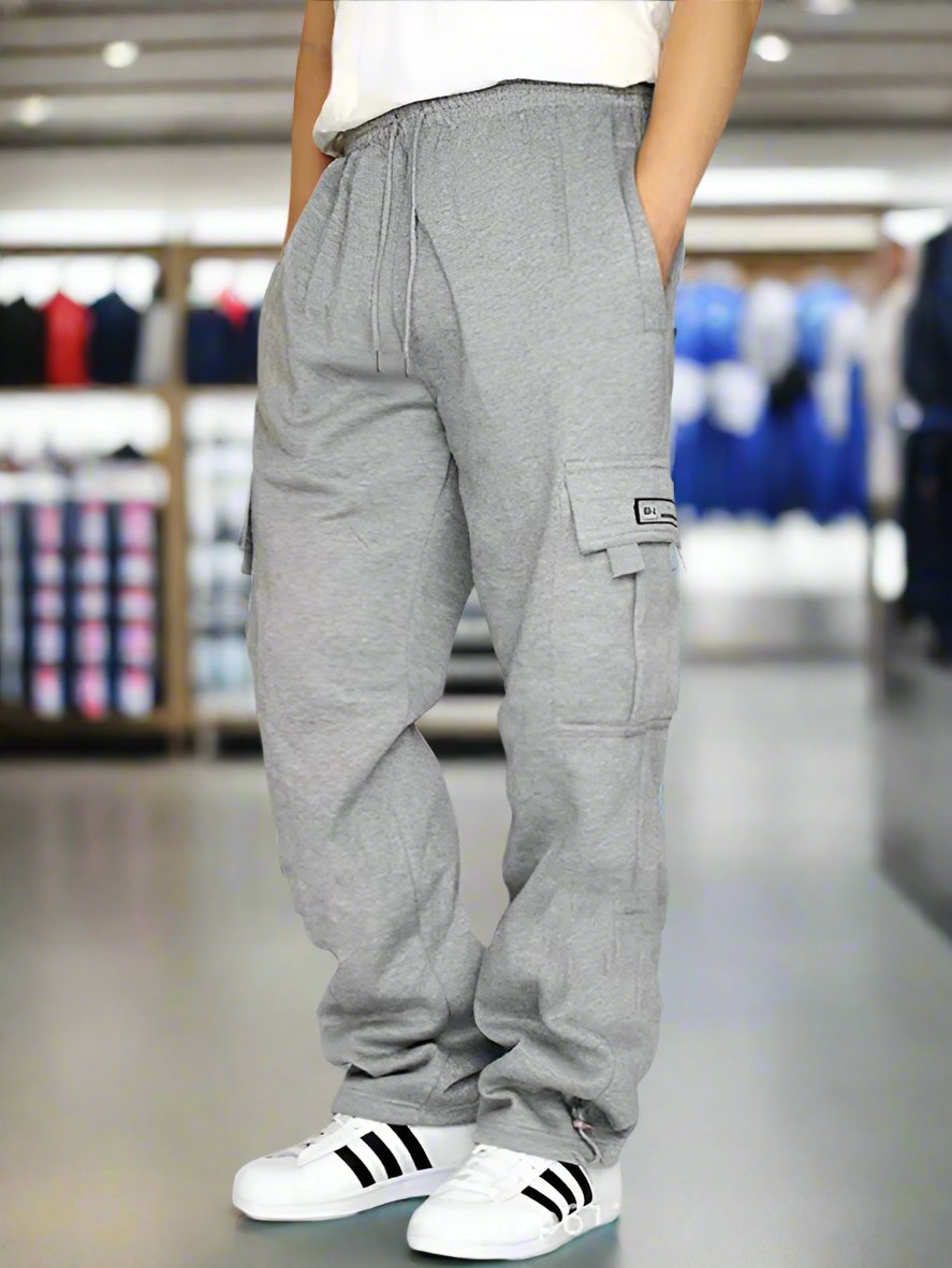 Made of 100% Polyester for a durable and comfortable wear, these loose jogging pants are perfect for sports and leisure activities. Featuring multiple pockets and a tether design, these pants combine functionality and style, making them a standout choice for men. Pair these pants with a simple t-shirt and sneakers for a casual and trendy look that is perfect for everyday wear. Suitable for a variety of occasions, these joggers can be worn for outdoor activities, sports, or just hanging out with friends. Des