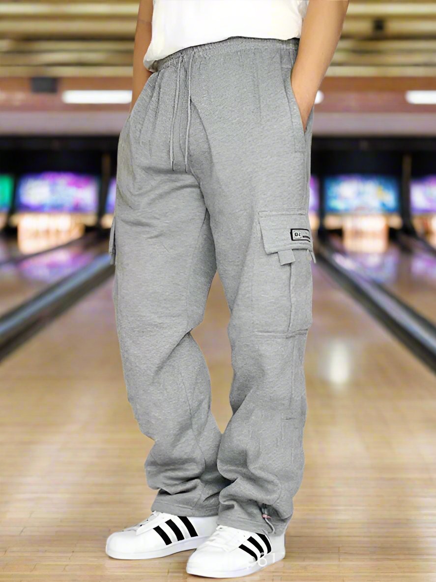 Made of 100% Polyester for a durable and comfortable wear, these loose jogging pants are perfect for sports and leisure activities. Featuring multiple pockets and a tether design, these pants combine functionality and style, making them a standout choice for men. Pair these pants with a simple t-shirt and sneakers for a casual and trendy look that is perfect for everyday wear. Suitable for a variety of occasions, these joggers can be worn for outdoor activities, sports, or just hanging out with friends. Des